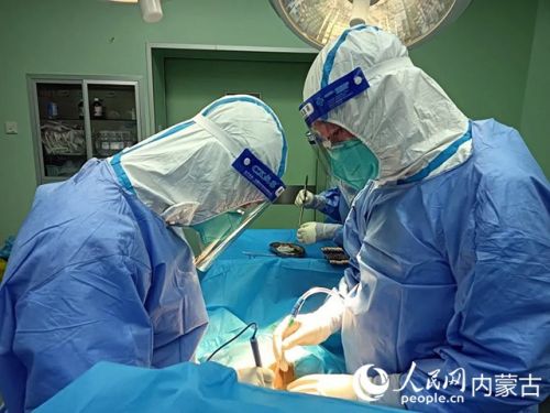 医护人员正在为新冠肺炎合并肠梗阻肠穿孔的尿毒症患者实施急诊手术。呼和浩特市第一医院供图
